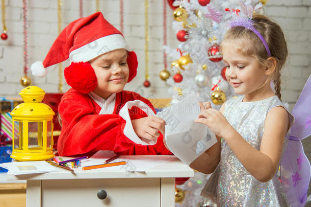 打扮成圣诞老人的女孩在信封里放了一封祝贺信，信封里装着女孩仙女
