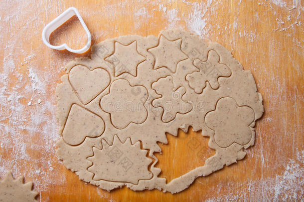 面团用于姜饼饼饼干和饼干切割机在轻型木制切割板上的不同形状，如背景
