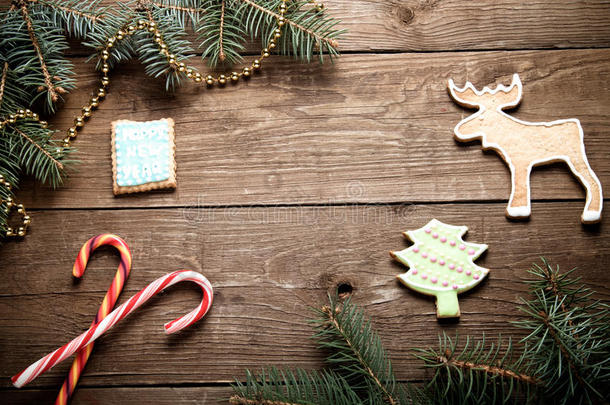 姜饼自制<strong>饼干</strong>与糖霜和圣诞树树枝在木制桌子或<strong>木板上</strong>作为背景。 新年主题。 色调