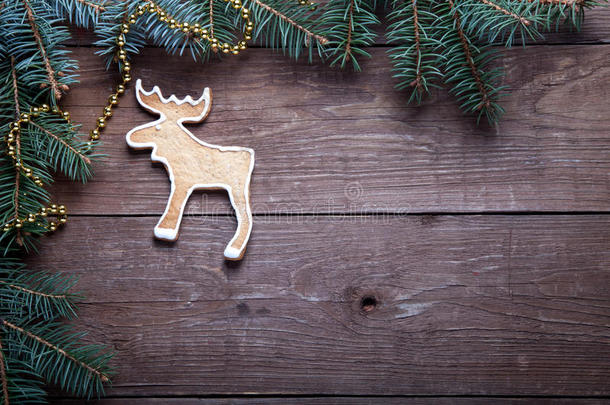 姜饼自制饼干与糖霜和圣诞树树枝在木制桌子或木板上作为背景。 新年主题