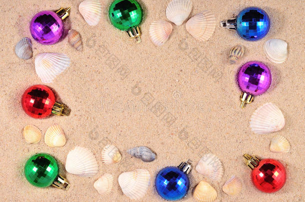 五颜六色的圣诞装饰品和沙滩上的贝壳