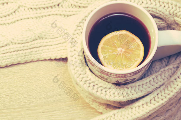 一杯加柠檬的热茶，在木制背景上戴上温<strong>暖</strong>的<strong>冬季</strong>围巾
