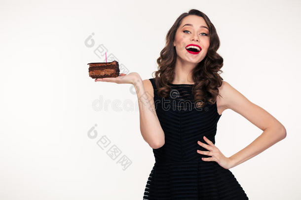 欢快的女人拿着一块带蜡烛的巧克力生日蛋糕