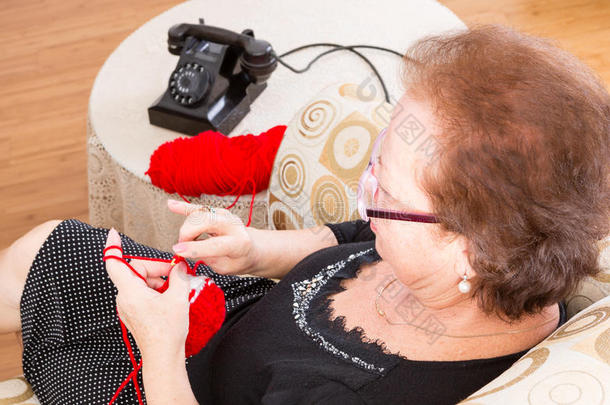 奶奶坐在手机附近编织