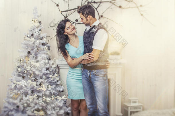 美丽的一对男女拥抱在圣诞节的内部