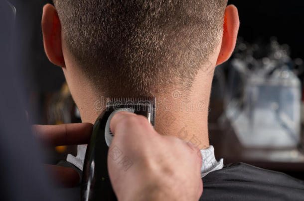 理发师用电动剪发器剪客户的头发