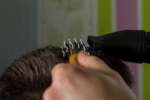 美发师在专业美发沙龙为客户做毛刷和吹风机