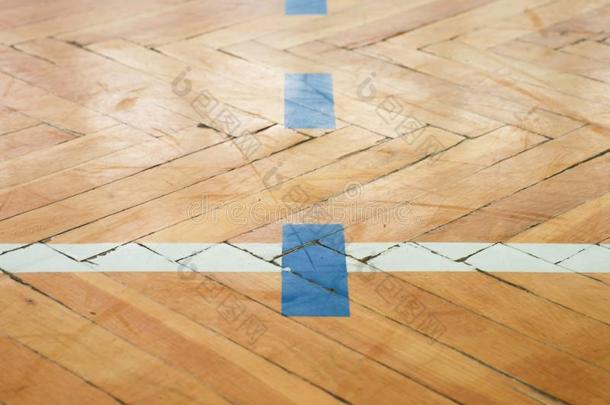 蓝色的白色线条。 体育馆的木地板磨损，有五颜六色的标志线。