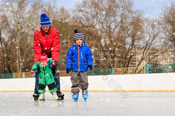 父亲和两个孩子在冬天滑冰，家人