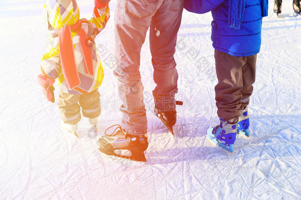 父亲和两个孩子在冬天滑冰
