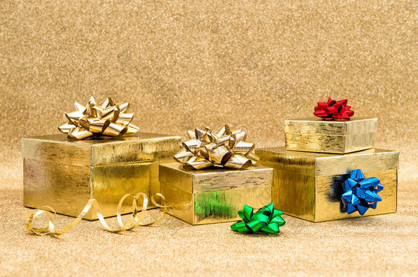 金色背景上带丝带蝴蝶结的礼品盒
