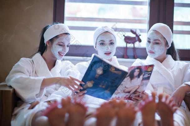 <strong>单身派对</strong>在水疗中心，女孩带着面具阅读杂志