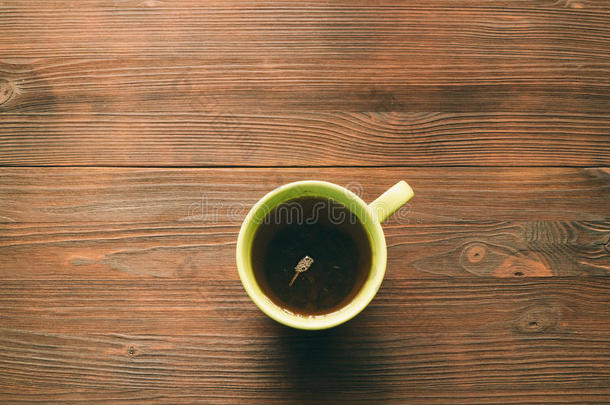 绿色的<strong>茶</strong>杯在木制桌子顶部的视图