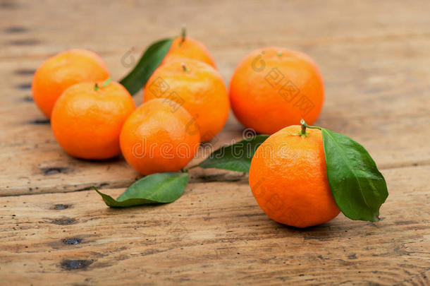 新鲜的橘子水果，旧木桌上有叶子