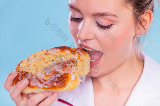 营养师吃甜卷面包。 不健康的食物。