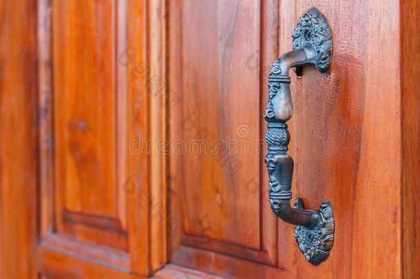 门把手。 棕色木门。 门把手是铝的