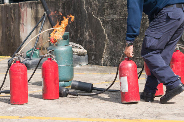 煤气管燃烧时，消防员手持灭火器灭火博士