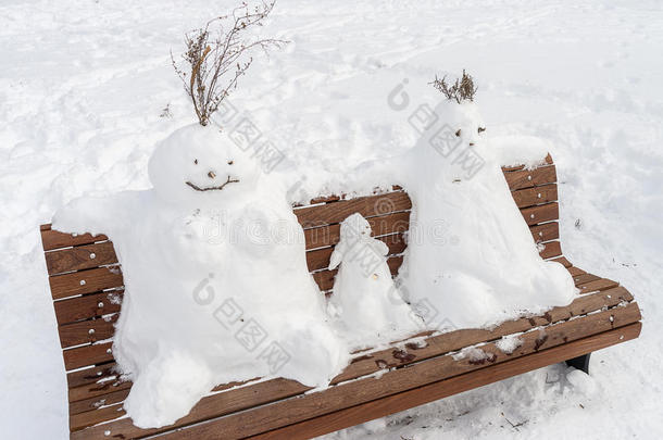 在长凳上堆雪人的家人