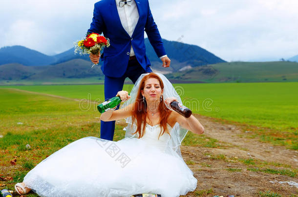 醉醺醺的新娘在山上有很多空啤酒瓶，新郎转向她-有趣的婚礼概念。