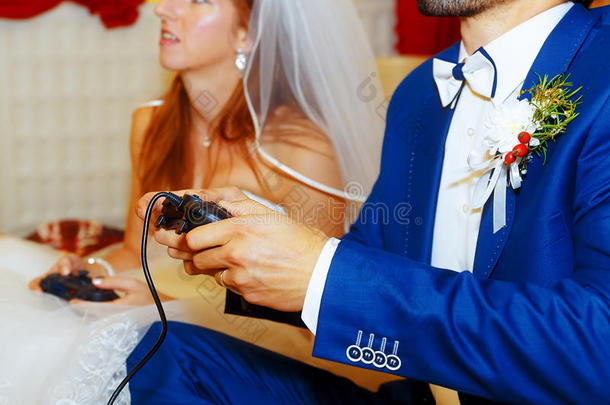 新娘和新郎一起玩电子游戏与操纵杆-游戏和婚礼的概念。