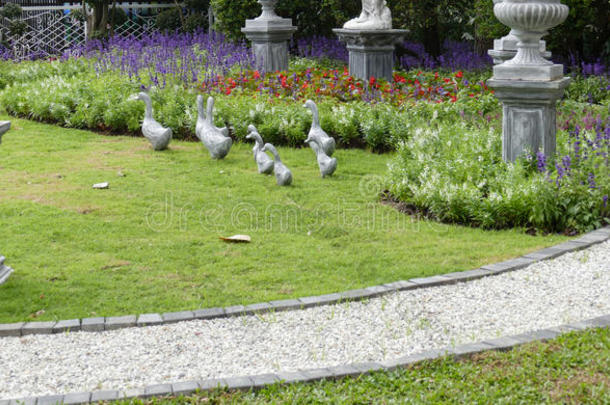 鸭雕像装饰在花坛附近