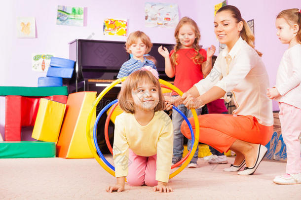 女孩爬在塑料圈，<strong>幼儿园</strong>小组