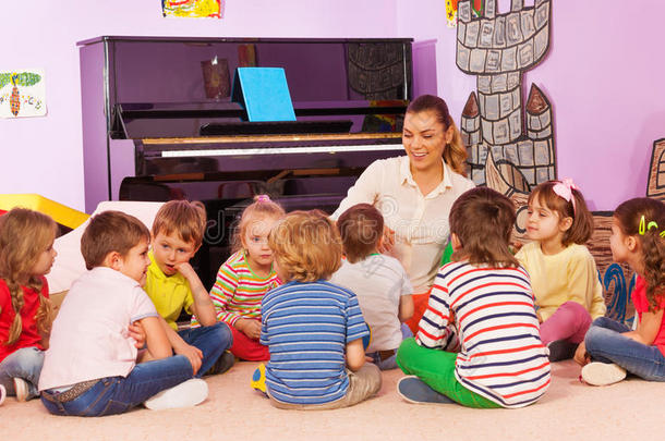 一群孩子坐着听老师讲故事