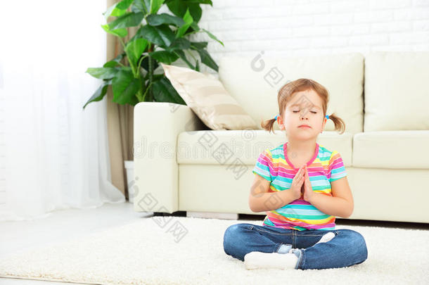 小女孩在莲花位置冥想并练习瑜伽