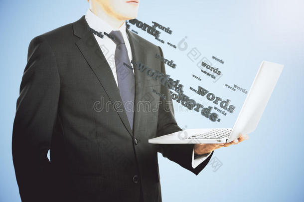 商人带着笔记本电脑，上面的单词在飞