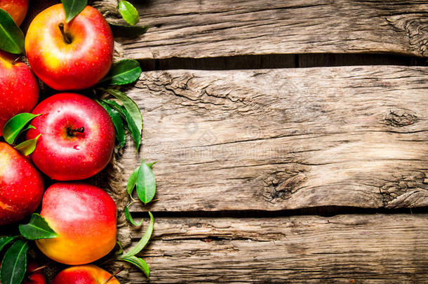 木制桌子上有绿叶的<strong>新鲜红苹果</strong>。