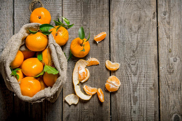 芬芳的橘子放在一个旧袋子里，拿着一把刀和剥了皮的橘子。
