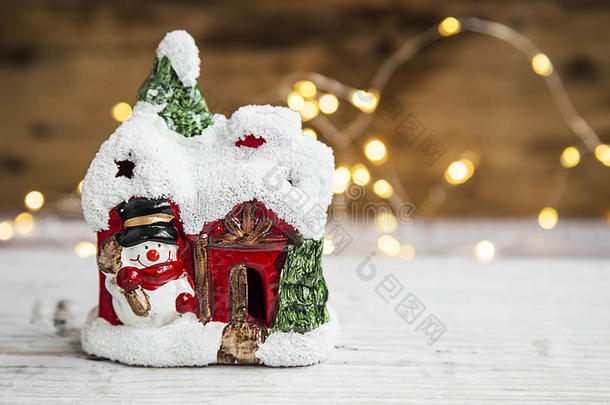节日圣诞屋装饰与小雪人和背景灯