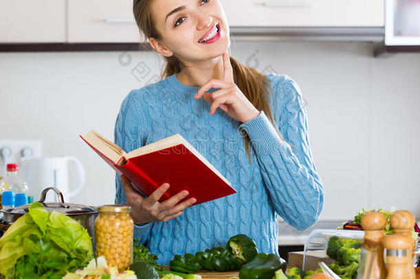 穿套衫的女孩从食<strong>谱</strong>中学习新的食<strong>谱</strong>