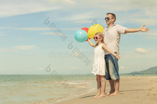 爸爸和女儿在爸爸的海滩上玩气球