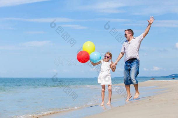 爸爸和女儿在爸爸的海滩上玩气球