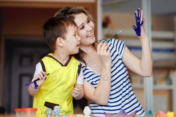 好奇的童年，一个小男孩和他的母亲玩耍，画画，在手掌上画画。