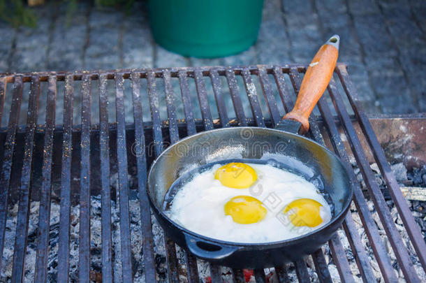 煎鸡蛋在烤架上的平底锅里煎