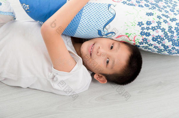 亚洲男孩躺在地板上。
