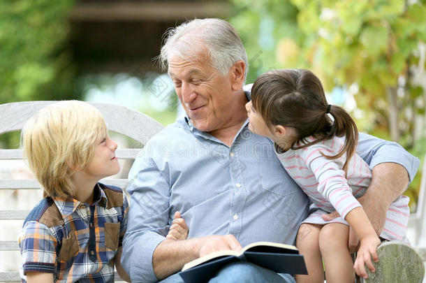 祖父在花园里给孙子们读故事