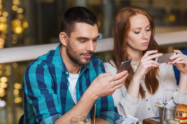 一对夫妇在餐厅用智能手机吃饭