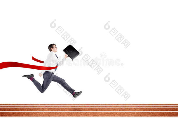 一个年轻的商人在<strong>赛道</strong>上奔跑，手里拿着一个黑色的文件夹，穿过<strong>红色</strong>的终点线。