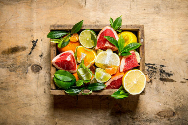 一盒柑橘类水果-柚子，橘子，橘子，柠檬，石灰和叶子。