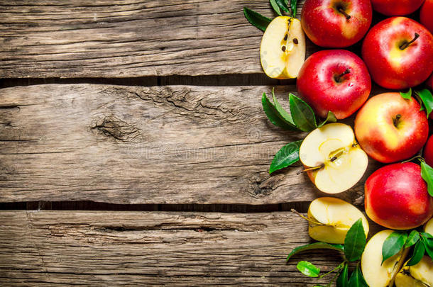 木制桌子上有绿叶的<strong>新鲜红苹果</strong>。