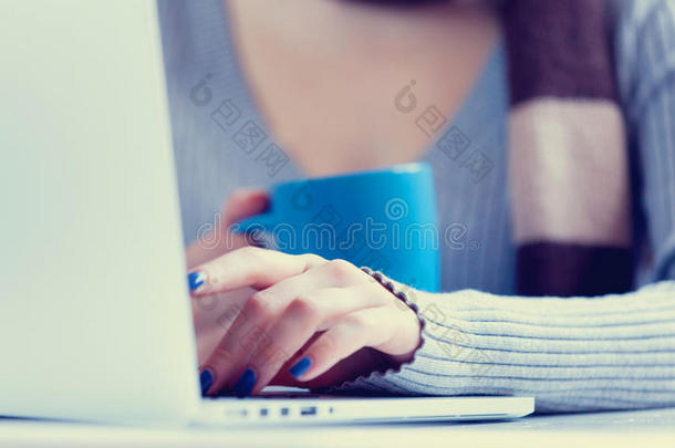 杯子靠近一个带笔记本电脑的女人