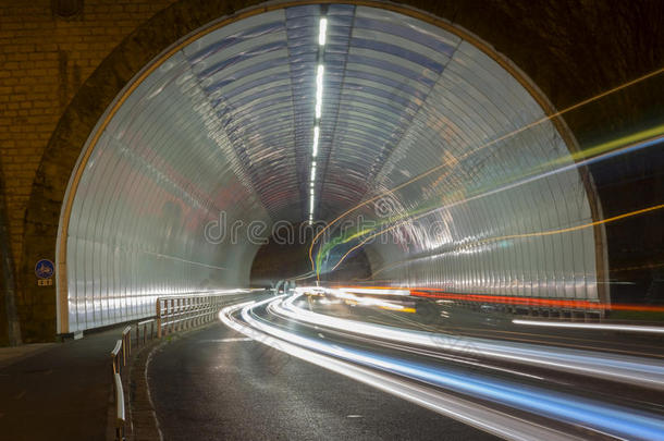 汽车灯在隧道里，城市在晚上。