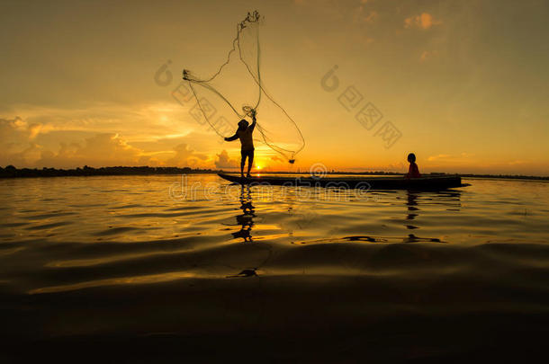 渔民和孩子们在河里钓鱼，一个金色的剪影