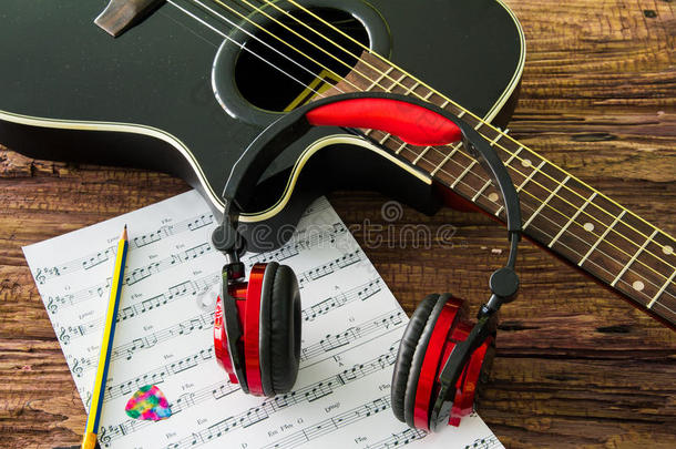 吉他，耳机和桌子上的音符。