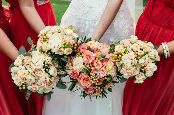 新娘穿着婚纱，伴娘着<strong>红装</strong>，在仪式上拿着婚礼花束