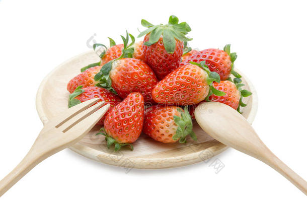 用勺子和叉子在<strong>木碟</strong>里放新鲜草莓
