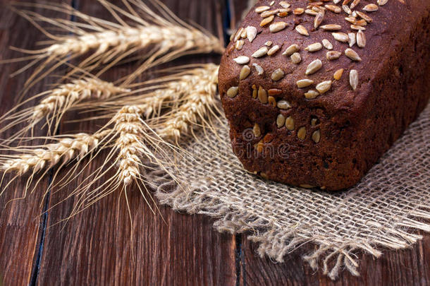 木制的黑色谷物面包和小麦